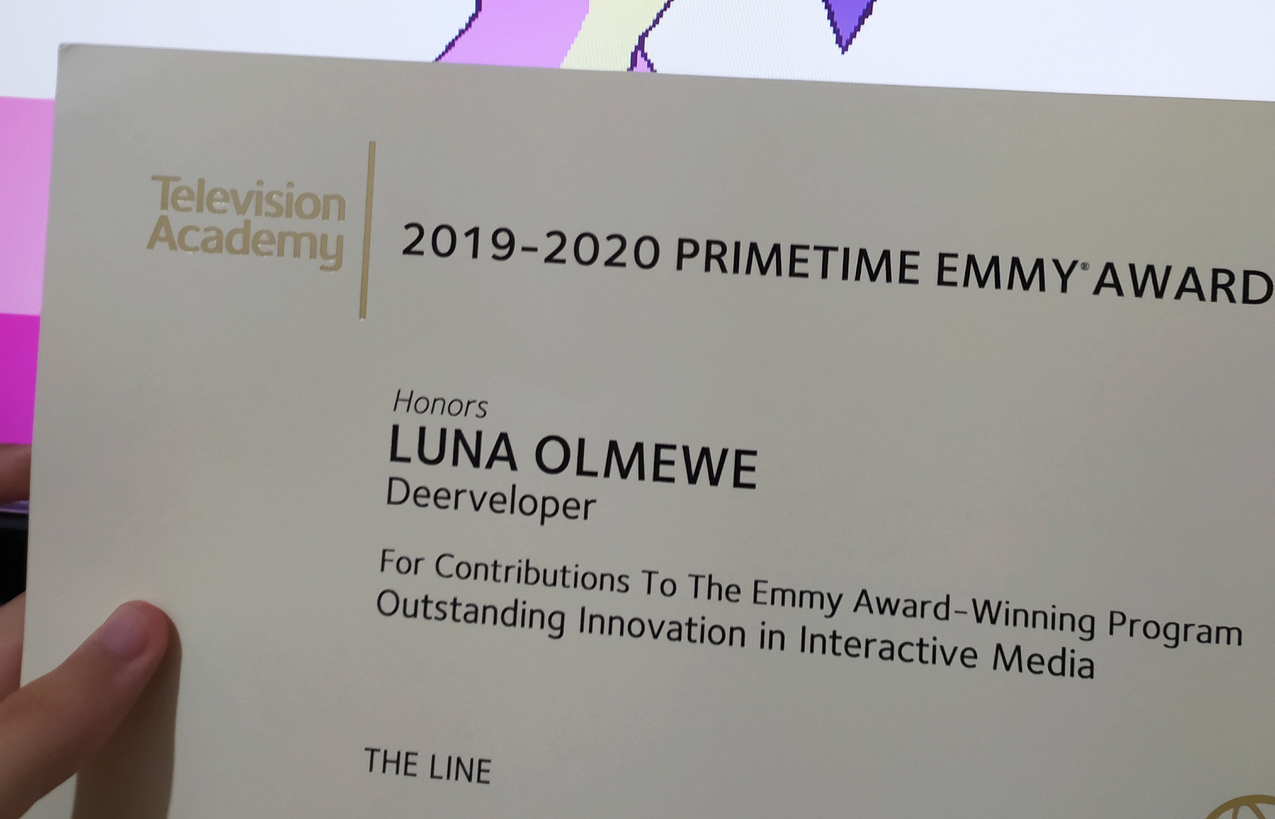 an award certificate, written "Television Academy; 2019-2020 Primetime Emmy Award; Honors LUNA OLMEWE, Deerveloper, For Contributions To The Emmy Award-Winning Program; Outstanding Innovation in Interactive Media: THE LINE"